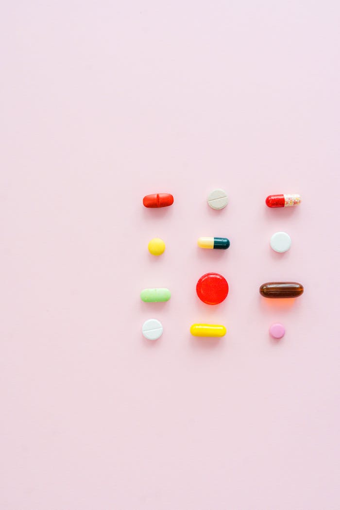 our-services-1 Vibrant assortment of pills and capsules arranged on a soft pink background.